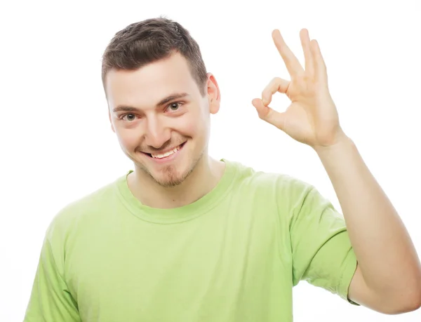 Young man in green shirt  showing thumbs up. Royalty Free Stock Images