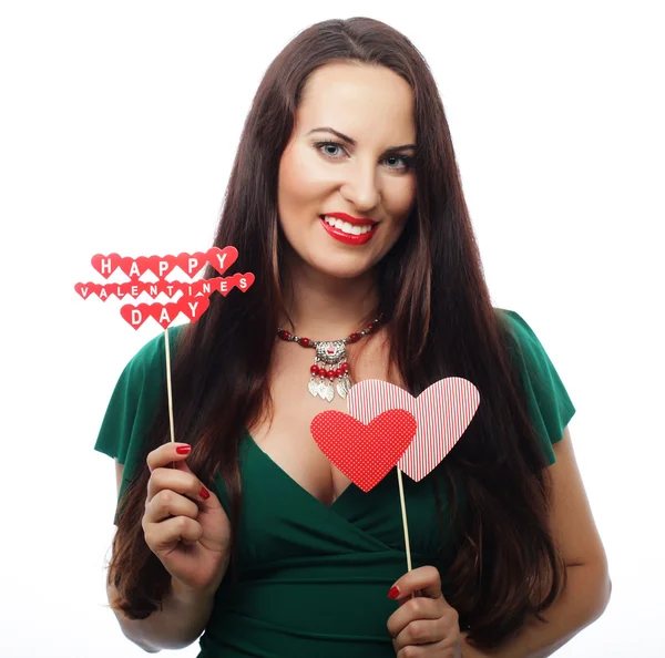 Beautiful woman wearing green dress holding paper hearts — Stock Photo, Image