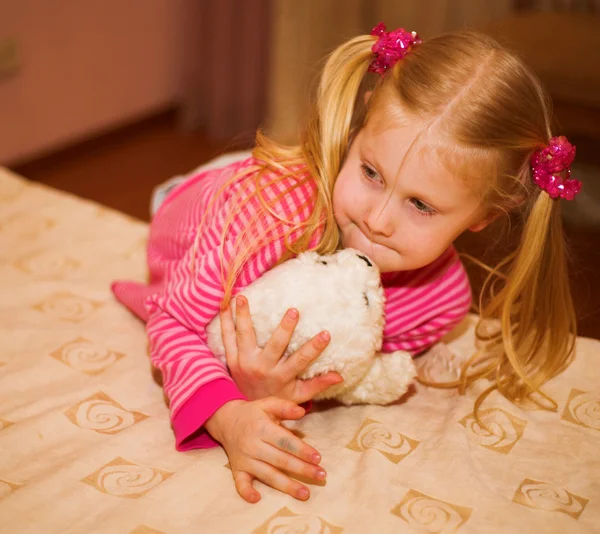 Menina loira com um brinquedo macio — Fotografia de Stock