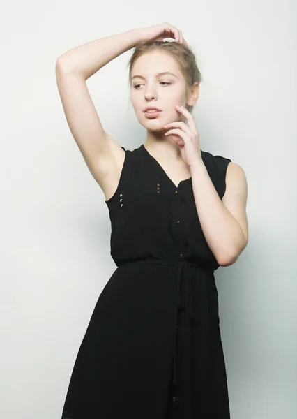 Ungt mode blond kvinna i svart klänning poserar i studio — Stockfoto