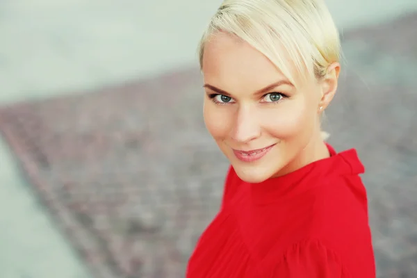 Szczęśliwa młoda blond kobieta, na sobie czerwoną sukienkę — Zdjęcie stockowe
