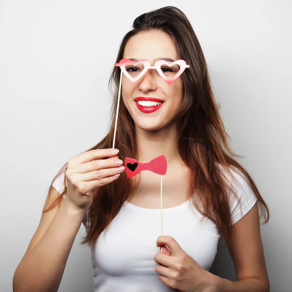 Imagen de fiesta. Jovencita juguetona sosteniendo unas gafas de fiesta . — Foto de Stock