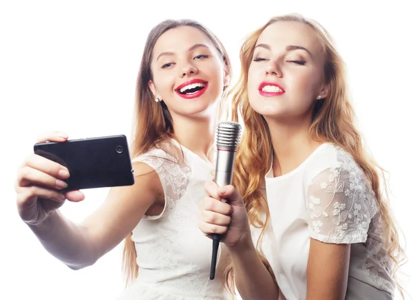 Mikrofonlu güzel kızlar şarkı söyleyip selfie çekiyorlar. — Stok fotoğraf