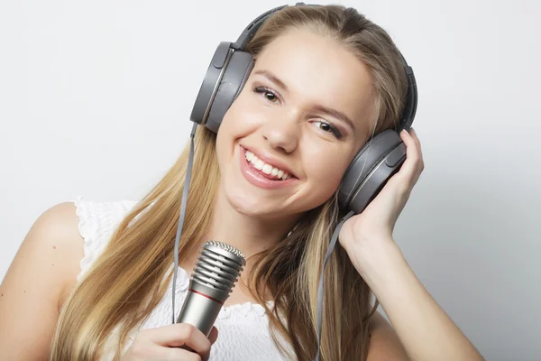 Belle jeune femme avec microphone et écouteurs — Photo