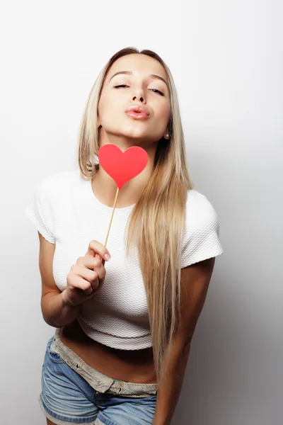 Jovencita juguetona sosteniendo un corazón de fiesta . — Foto de Stock