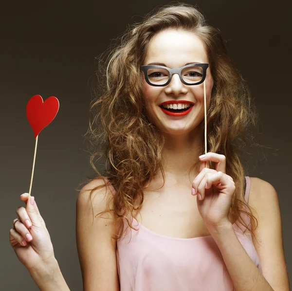 Imagen de fiesta. Mujeres jóvenes juguetonas sosteniendo unas gafas de fiesta . — Foto de Stock