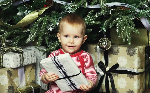 Dziecko dziewczynka z pudełko w pobliżu świąteczne dekorowanie tr — Zdjęcie stockowe