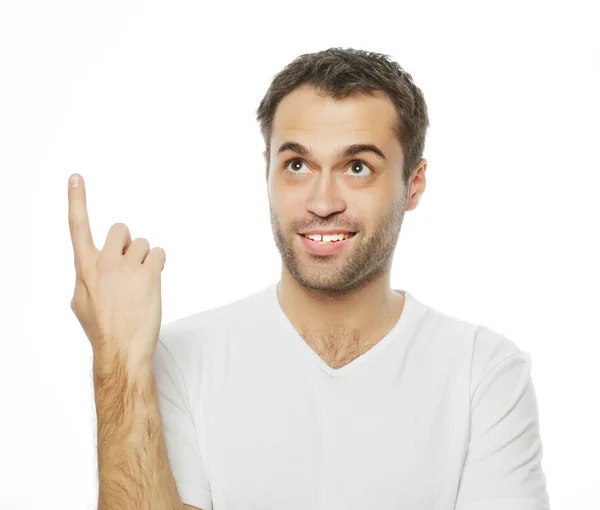 Young smiling happy man shows something — Stock Photo, Image