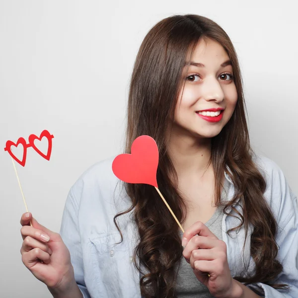 Jovencita juguetona sosteniendo un corazón de fiesta . — Foto de Stock