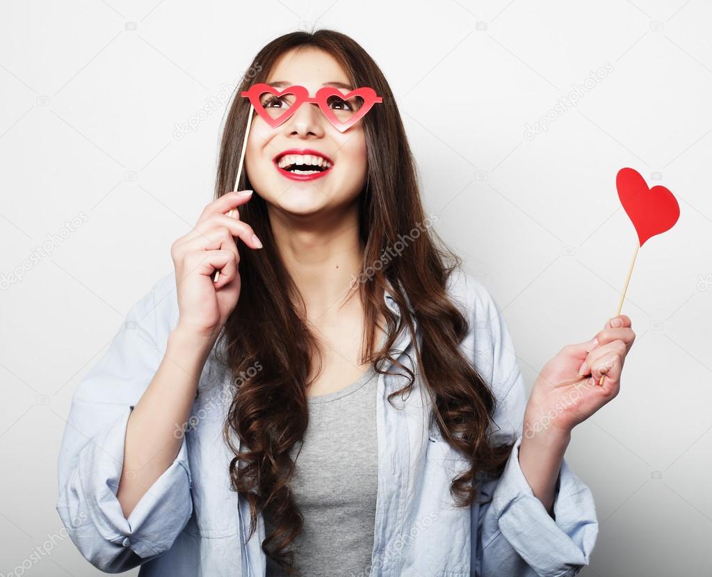 Playful young woman holding a party heart.