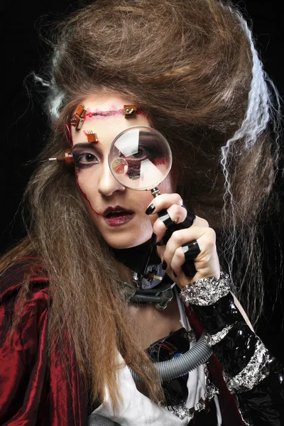 Woman with creative make up holding a magnifying glass — Stock Photo, Image