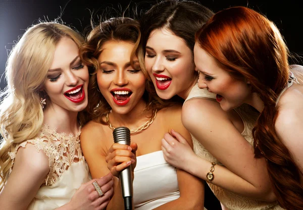 Quatro lindas garotas elegantes cantando karaoke — Fotografia de Stock