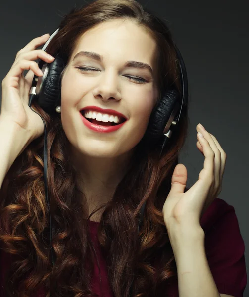 Mujer joven con auriculares escuchando música — Foto de Stock