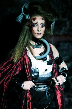 Kırmızı bir yağmurluk içinde yaratıcı makyaj ile genç kadın