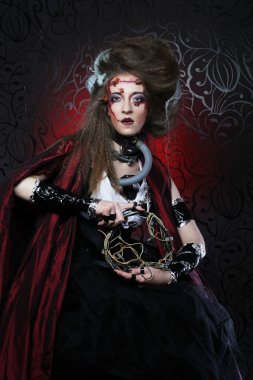 Kırmızı bir yağmurluk içinde yaratıcı makyaj ile genç kadın