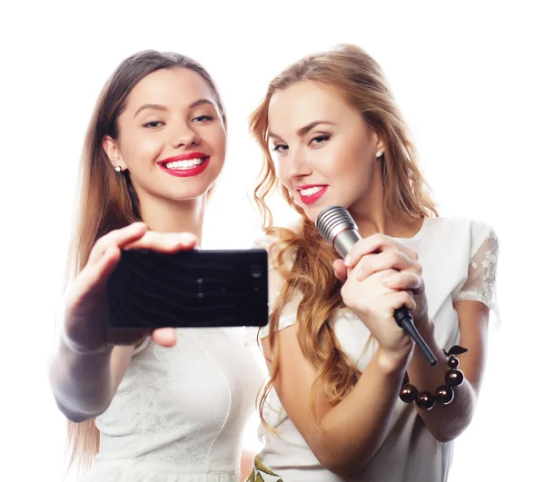 Skönhet flickor med en mikrofon sång och göra selfie — Stockfoto
