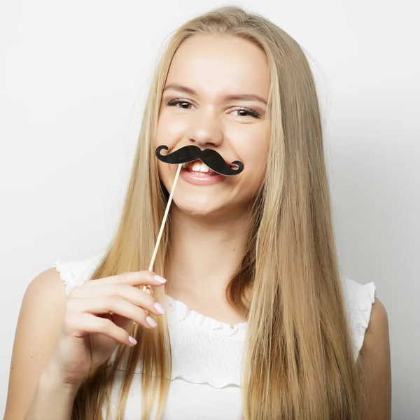 Ung kvinna som bär falska mustascher. — Stockfoto