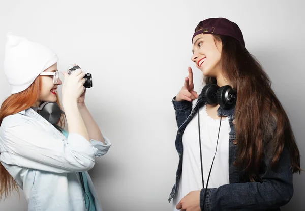 Glückliche Freundinnen beim Fotografieren, vor grauem Hintergrund — Stockfoto