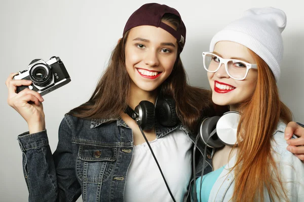 Felice ragazze amiche scattare alcune foto, su sfondo grigio — Foto Stock