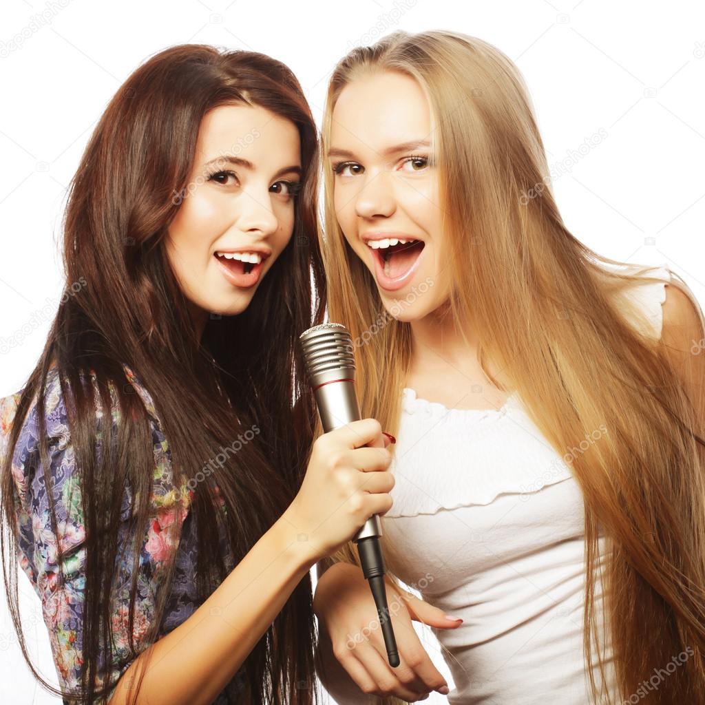 two beauty hipster girls with a microphone singing and having f