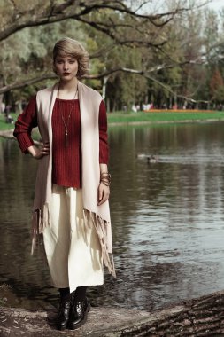 Bir ağaç üzerinde poz genç güzel kadın.