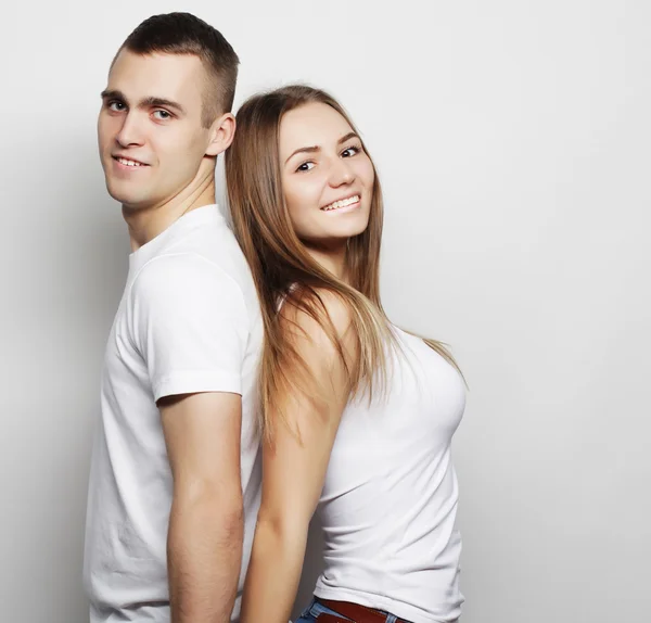 Schönes glückliches Paar, das sich vor grauem Hintergrund umarmt. — Stockfoto