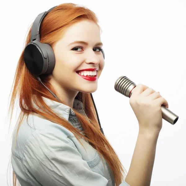Hermosa mujer joven con micrófono y auriculares — Foto de Stock