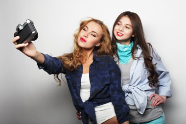 Mutlu kız arkadaş gri arka plan üzerinde bazı fotoğraf çekmek