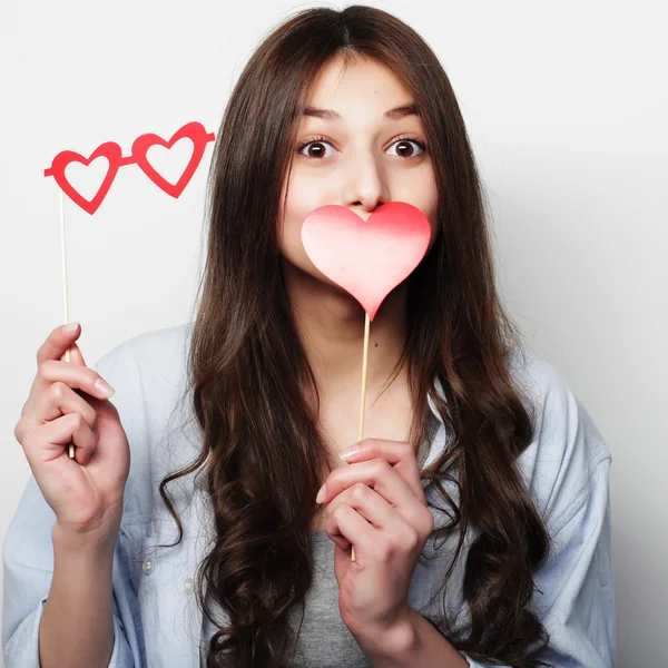 Jovencita juguetona sosteniendo un corazón de fiesta . — Foto de Stock