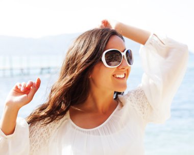 Mutlu kadın yaz beyaz elbise kumsalda.