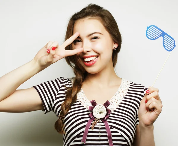 Mujeres jóvenes juguetonas sosteniendo unas gafas de fiesta . — Foto de Stock