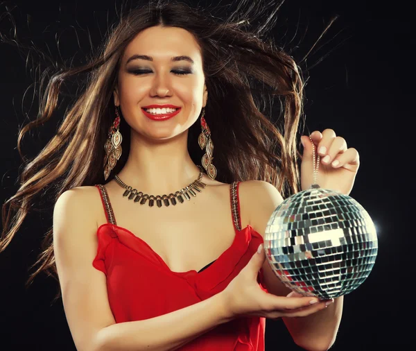 Jovem de vestido vermelho mantendo bola de discoteca — Fotografia de Stock