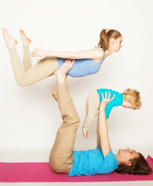 Mãe, pai e filho fazendo ioga — Fotografia de Stock