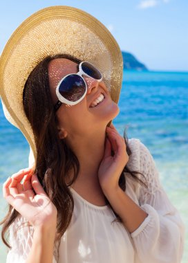 Sahilde şapkalı mutlu kadın