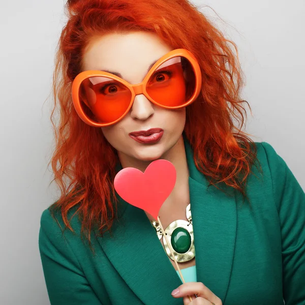 Mujer sosteniendo un partido corazón y gafas . — Foto de Stock