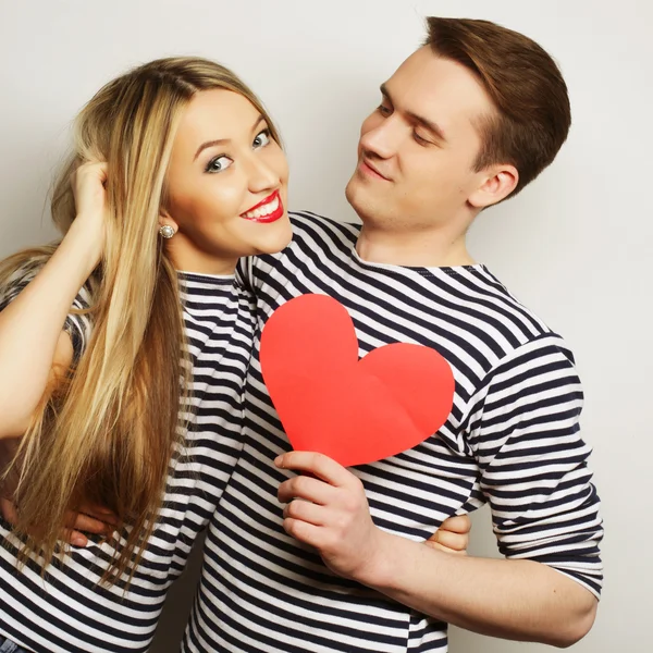 Casal feliz no amor segurando coração vermelho — Fotografia de Stock