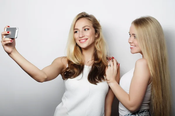 Dos mujeres jóvenes tomando selfie con teléfono móvil — Foto de Stock