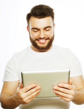 Genç adam tablet bilgisayar kullanıyor.