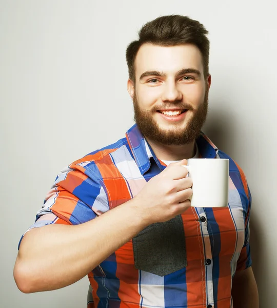 Ung skægget mand med en kop kaffe - Stock-foto