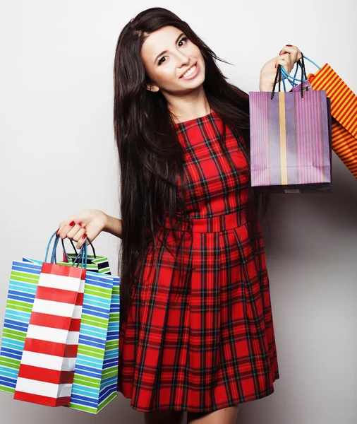 Alışveriş torbalarıyla gülümseyen genç kadının portresi. — Stok fotoğraf