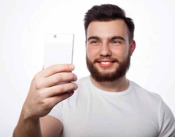 Fiatal szakállas férfi mobiltelefonnal — Stock Fotó