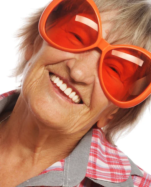 Ανώτερος ευτυχισμένη γυναίκα, φορώντας μεγάλα γυαλιά ηλίου, κάνει funky δράση — Φωτογραφία Αρχείου