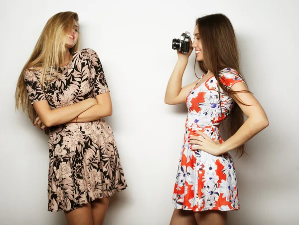 Meninas felizes amigos tirando algumas fotos, sobre fundo cinza — Fotografia de Stock