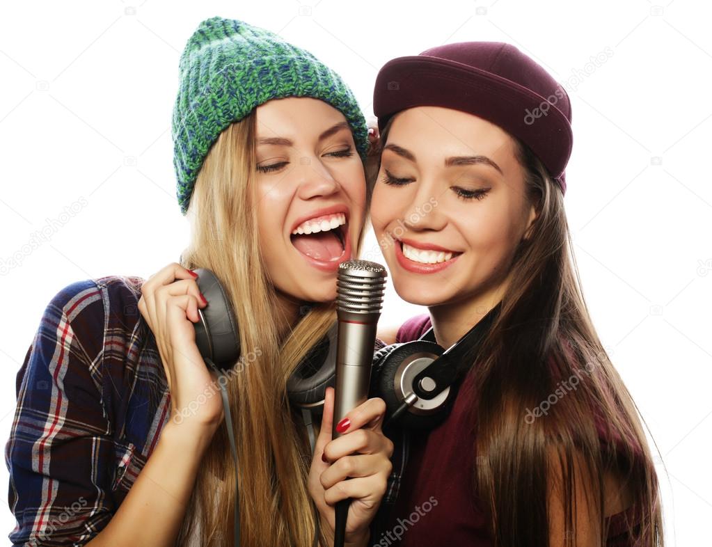 two beauty hipster girls with a microphone singing and having f