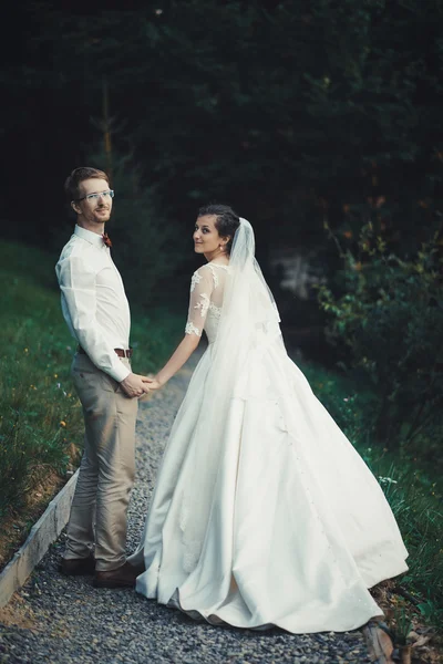 Una giovane sposa e lo sposo in piedi insieme all'aperto — Foto Stock