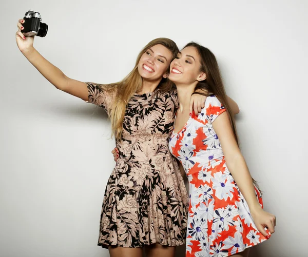 Glada tjejer vänner att ta några bilder, över grå bakgrund — Stockfoto