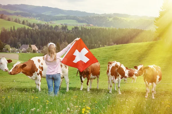 Fille tenant drapeau et vaches sur le pâturage — Photo