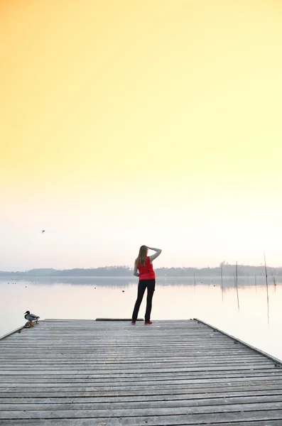 Girl on the wooden jetty. — Stock Photo, Image