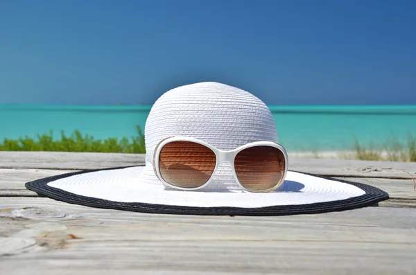 Sombrero y gafas de sol sobre fondo marino — Foto de Stock