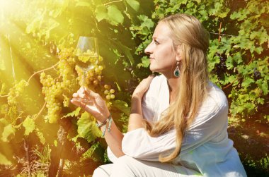 Üzüm bağları arasında beyaz şarap tatma kız. 